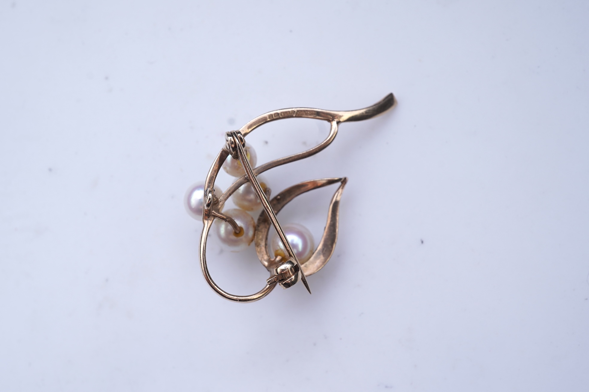 A group of cultured pearl jewels, comprising: two pairs of cultured pearl drop earrings, longest 3cm, mounted in gold; and two cultured pearl brooches mounted in 9ct gold, longest 4.1cm, British hallmarks, combined gross